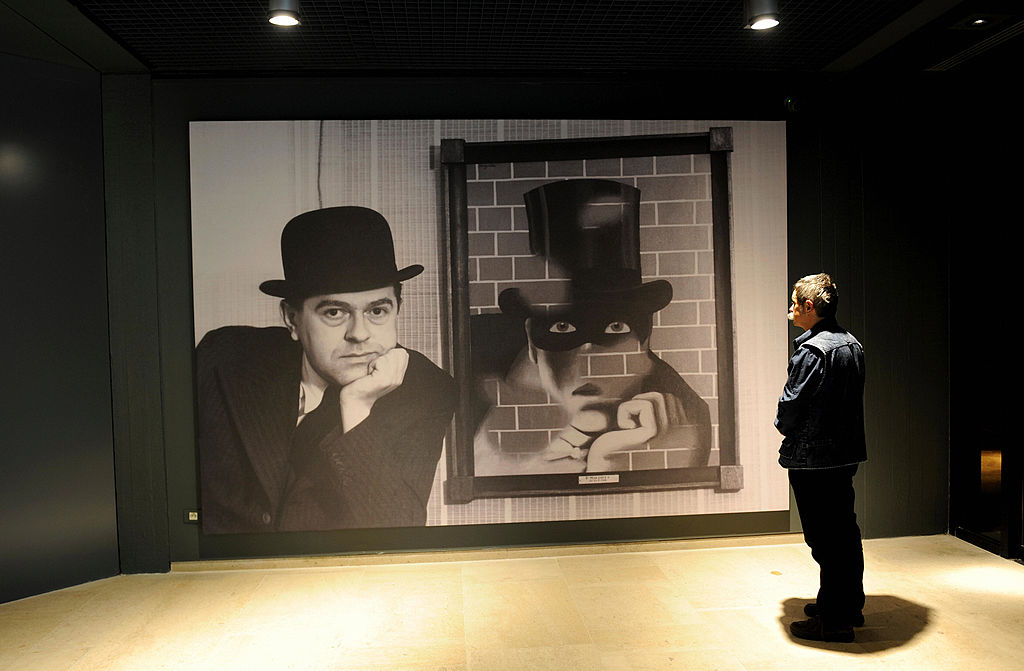 Visitors looks at a painting of the Belgian artist Rene Magritte at the press opening of the new Margitte museum in Brussels on May 20, 2009