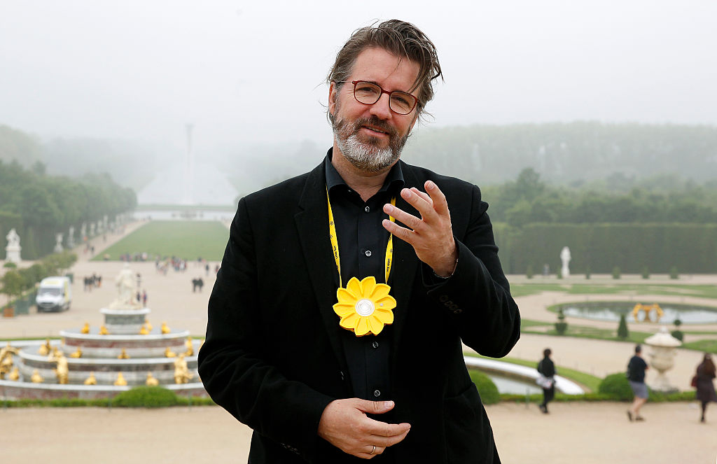 Artist Olafur Eliasson poses in front of his artwork named “Waterfall” at the opening of the exhibition of his works in the gardens of the Chateau de Versailles on June 6, 2016, in Versailles, France